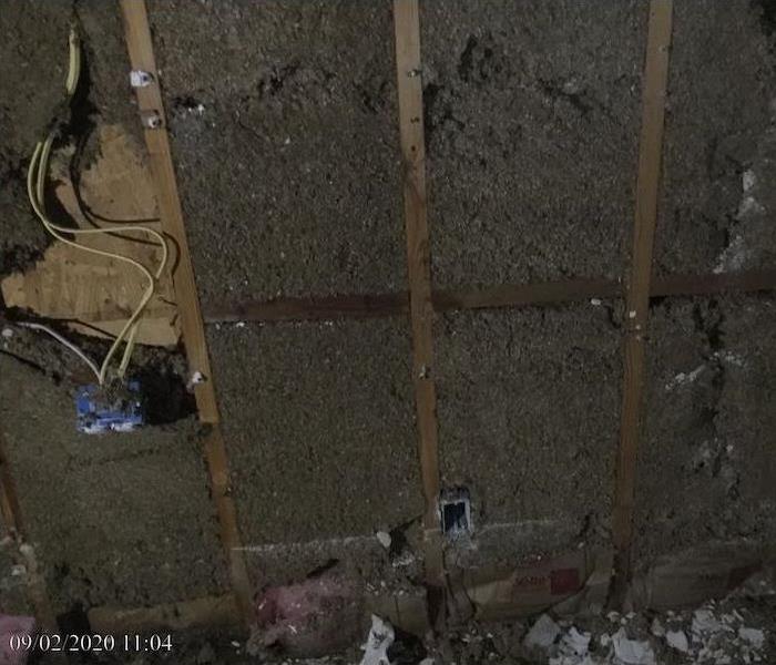 Wall with deteriorated sheetrock and debris