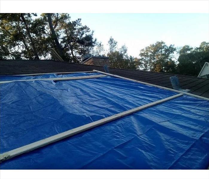 Roof with blue tarp securely in place