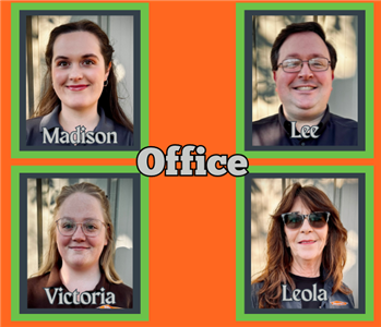 Four office team members in various SERVPRO attire standing in front of a white background