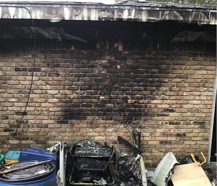 Exterior of home with charring and debris nearby