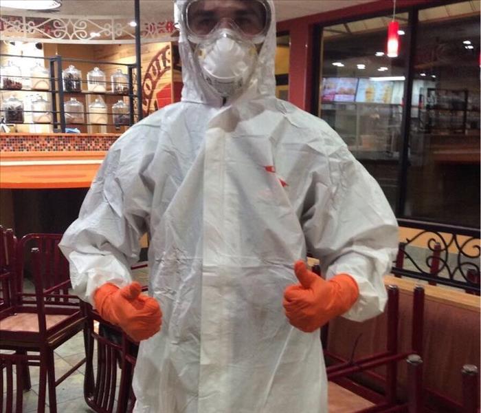 EMPLOYEE POSING IN TYVEK SUIT AND RESPIRATOR