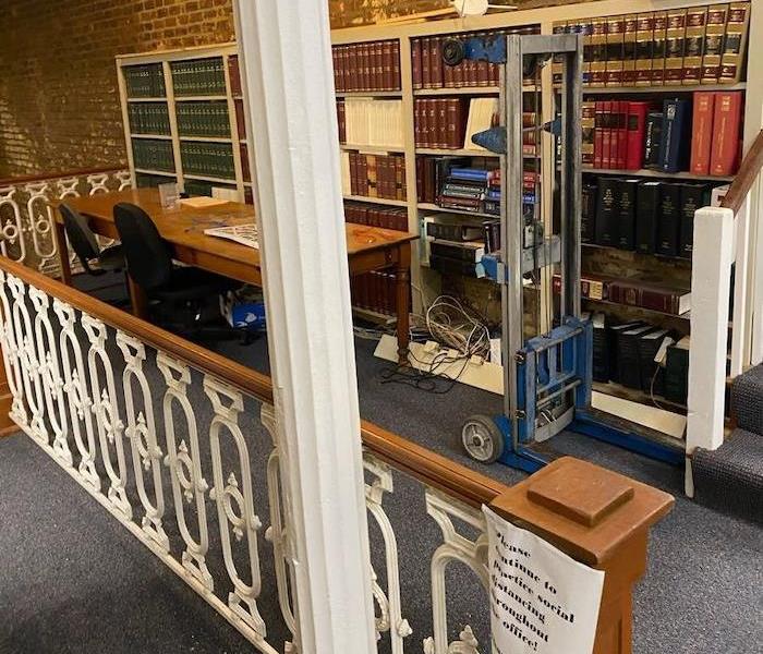 Office with books on bookshelves with desks and chairs