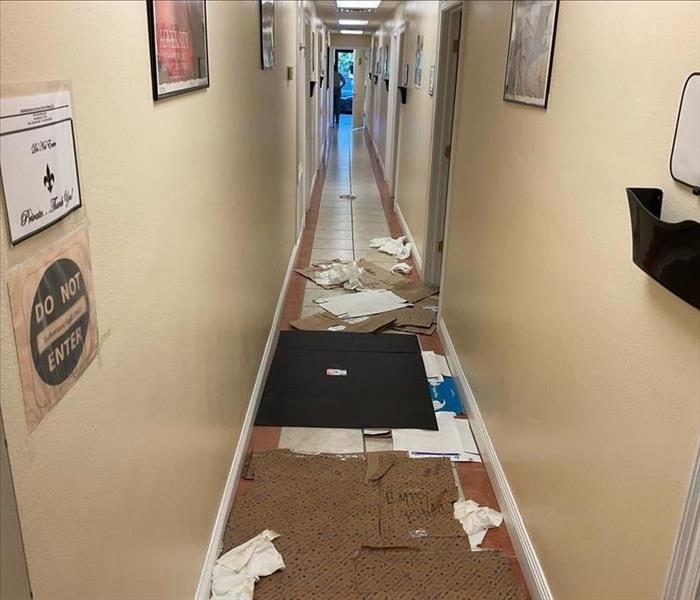 Hallway in an office with deteriorated floors and debris
