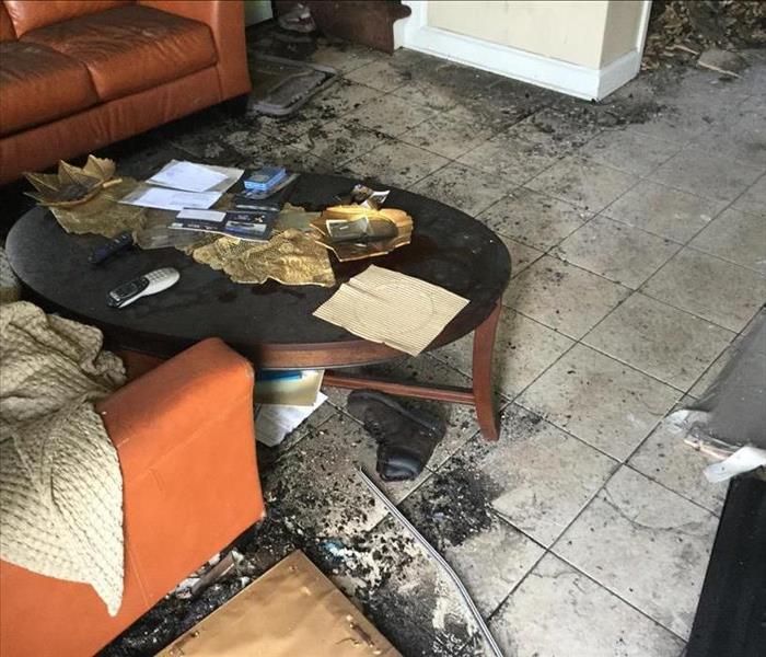 charred debris and mess in a living room, round table