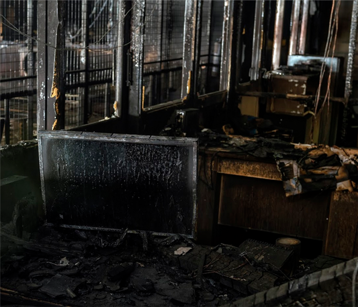 a fire damaged office with soot covering the desks and debris everywhere