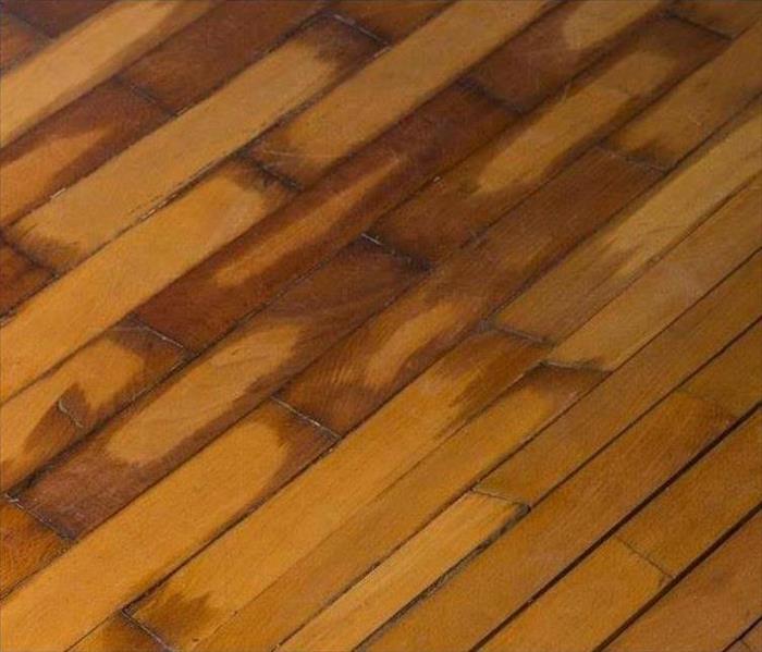 a water damaged hardwood floor that has warped floor boards