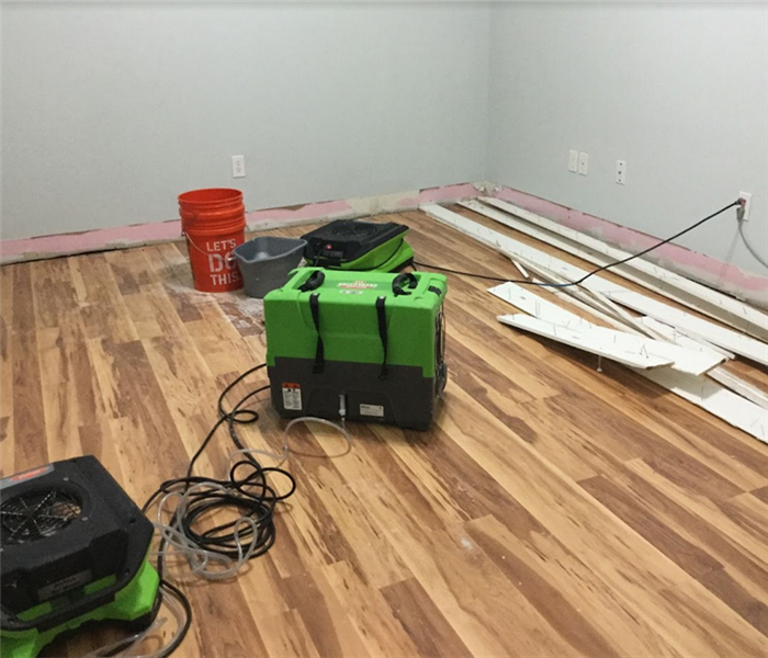 SERVPRO equipment working to fix the water damage in the room of a house