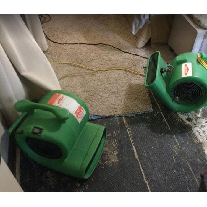SERVPRO restoration equipment being used on water damaged floor and carpet